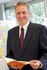 Präsident Florian Scheurle mit aufgeschlagener Dokumentenmappe